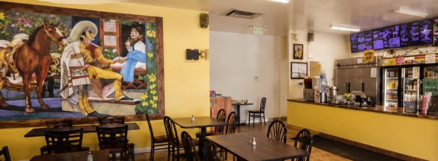Dining room at Birria Patro Jaramillo with hand-painted mural